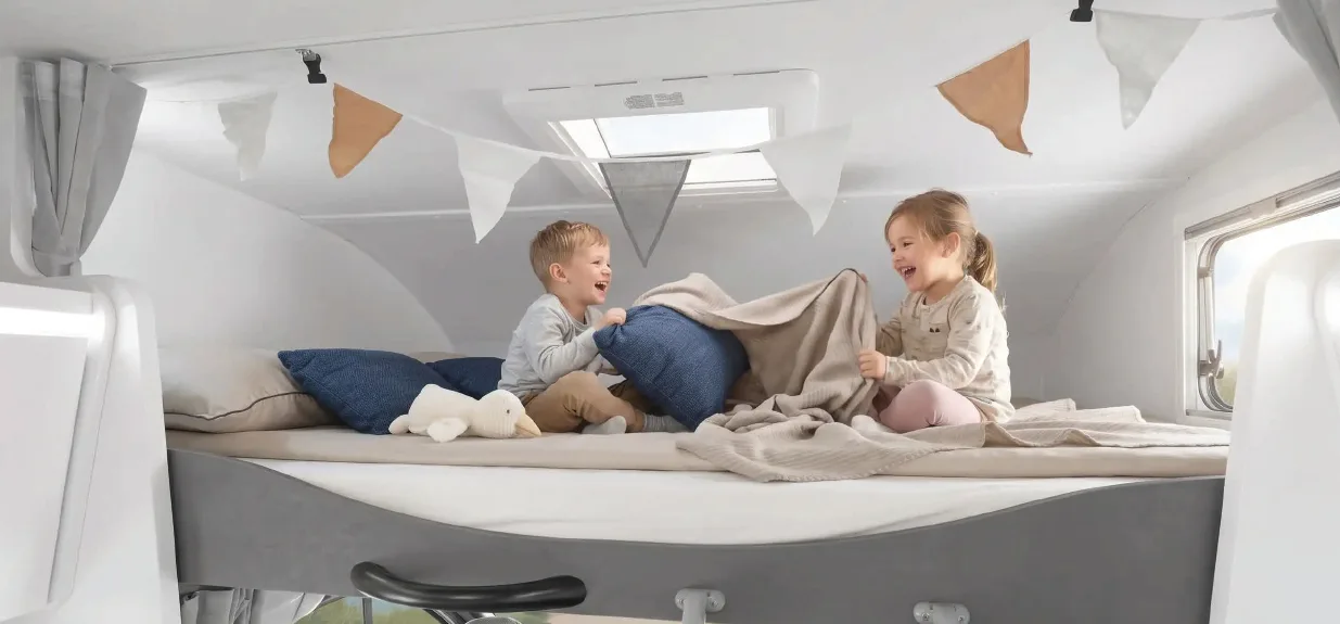 Kinderen spelen in het alkoofbed van een Ahorn Camp