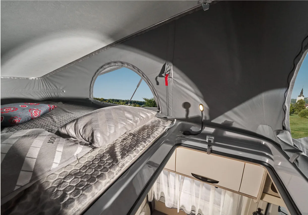 Bed onder het pop-up dak van een Bravia Mobil